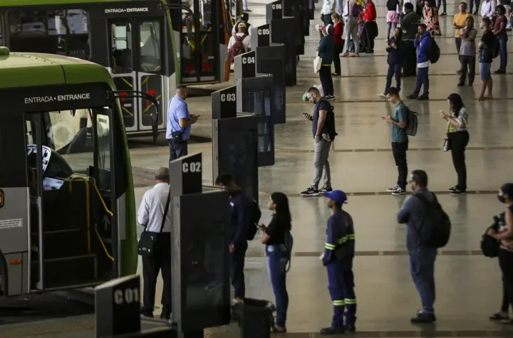 Brasília (DF), 09/08/2023 - Movimentação de passageiros e ônibus na Rodoviária do Plano Piloto. Nos dias 8 e 9 de agosto acontece, em Brasília, o 36º Seminário Nacional de Transporte Urbano, em que empresários, entidades de classe, especialistas e representantes de governo debatem as mudanças necessárias no setor. Foto: Marcelo Camargo/Agência Brasil© Marcelo Camargo/Agência Brasil Versão em áudio A auxiliar de serviços gerais Núbia Sales Veras, de 52 anos, moradora da Cidade Ocidental, município goiano no Entorno do Distrito Federal, utiliza diariamente o transporte público para cruzar o limite com a capital do país e chegar até a empresa onde trabalha, no Lago Sul, bairro de elite de Brasília, a cerca de 50 quilômetros (km) de casa. A distância, o custo da tarifa do ônibus e a baixa qualidade do transporte urbano criam limitações para que ela acesse serviços essenciais da sua vida, como o tratamento que faz para fibromialgia, uma síndrome crônica que causa dores musculares e articulares em várias partes do corpo. "Já perdi compromisso, já perdi consulta do meu tratamento no [hospital] Sarah [instituição de saúde focada em reabilitação motora e neurológica], tudo por causa da demora do ônibus e do valor da passagem", contou à Agência Brasil. A reportagem conversou com Núbia, na tarde da última sexta-feira (12), quando ela passava pela Rodoviária do Plano Piloto, o principal terminal de transporte público urbano do Distrito Federal e região metropolitana, localizada no centro da capital do país. Outro problema relatado pela trabalhadora é o valor da passagem, que chega a custar R$ 18 por dia, custo que limita sua vida social. Brasília (DF), 13/06/2026 - Núbia Sales Veras fala sobre tarifa zero pode garantir mais acesso a serviços de saúde. Foto: Pedro Rafael Vilela/Agência Brasil Núbia afirma que filhas perderam oportunidades por causa do preço da passagem. Foto: Pedro Rafael Vilela/Agência Brasil "Muitas vezes não pude utilizar para a cultura, para colocar minhas filhas em uma escola melhor, mas mais distante, por causa desse valor da passagem", afirmou. A experiência de Núbia, bem como de milhares de pessoas que usam o transporte público rodoviário para transitar pelas grandes cidades do país, reflete as conclusões de um novo estudo desenvolvido por pesquisadores vinculados ao Instituto de Ciência Polícia da Universidade de Brasília (UnB). O artigo intitulado Quem pode circular? Tarifa zero, mobilidade e desigualdades raciais no acesso à cidade e aos serviços aponta que o custo tarifário e a precariedade do transporte, incluindo superlotação, insegurança e imprevisibilidade, geram obstáculos concretos à continuidade do cuidado em saúde, resultando no atraso de diagnósticos, faltas a consultas agendadas e prejuízos no acompanhamento preventivo de doenças crônicas. Racismo estrutural O texto, publicado no formato policy paper (um tipo de relatório técnico), destaca que os tempos de deslocamento prolongados em regiões metropolitanas "atuam como severos agravantes de sofrimento psíquico, estresse crônico e exaustão, potencializando quadros de ansiedade e depressão". Esses efeitos, de acordo com a pesquisa, tendem a ser particularmente significativos quando observados sob a perspectiva das desigualdades raciais. Isso porque a população negra está sobrerrepresentada entre os grupos de menor renda, residentes em territórios periféricos e mais dependentes do transporte público. "Isso significa que as barreiras econômicas e territoriais à mobilidade incidem de forma desproporcional sobre essa população, limitando seu acesso à cidade e aos seus serviços", aponta o estudo. Também na Rodoviária do Plano Piloto, a aposentada Helena Simão, mulher negra de 72 anos, caminhava devagar e com dificuldade quando parou para conversar com a reportagem, pouco antes de embarcar no ônibus para chegar a Samambaia, região administrativa do DF, distante cerca de 30 quilômetros do centro da capital. Ela contou que convive há anos com osteoporose, uma doença que reduz a densidade e enfraquece os ossos do corpo. Apesar de não pagar mais a tarifa, por ter gratuidade de pessoa idosa, Helena reclama da baixa circulação de ônibus na periferia. Brasília (DF), 13/06/2026 - Helena Simão fala sobre tarifa zero pode garantir mais acesso a serviços de saúde. Foto: Pedro Rafael Vilela/Agência Brasil Helena Simão não paga mais passagem, mas lamenta a pouca frequência de ônibus na periferia Foto: Pedro Rafael Vilela/Agência Brasil "Eu já não pago o transporte, mas demora muito para passar e já perdi consulta médica", denunciou Helena. Dados do DataSUS citados na pesquisa demonstram, por exemplo, que mulheres negras enfrentam o dobro do risco de morte materna em relação a mulheres brancas, "uma disparidade que se conecta diretamente às restrições materiais e espaciais de locomoção impostas pela segregação urbana". >>Livro debate tarifa zero e mobilidade urbana como qualidade de vida Transporte universal Um dos focos do estudo é demonstrar que a remoção da principal barreira econômica ao transporte público, que é o custo da tarifa, por meio da implantação da tarifa zero universal, tem potencial para atuar como uma política estruturante de redução de desigualdades, indo muito além de uma simples medida de transporte público. "Tem potencial de transformar a relação da sociedade com uma política pública, tal qual o Sistema Único de Saúde (SUS) propiciou, mas agora do ponto de vista do transporte", observa Paíque Duques Santarém, pesquisador da UnB (Universidade de Brasília) e um dos autores do artigo. Essa desoneração integral do custo da tarifa, na análise dos pesquisadores, constituiria uma ferramenta estratégica para garantir o acesso efetivo aos equipamentos públicos, assegurar a continuidade do cuidado terapêutico e "tensionar, de forma definitiva, os padrões históricos de exclusão territorial e racial que fragmentam as cidades brasileiras". © Marcelo Camargo/Agência Brasil